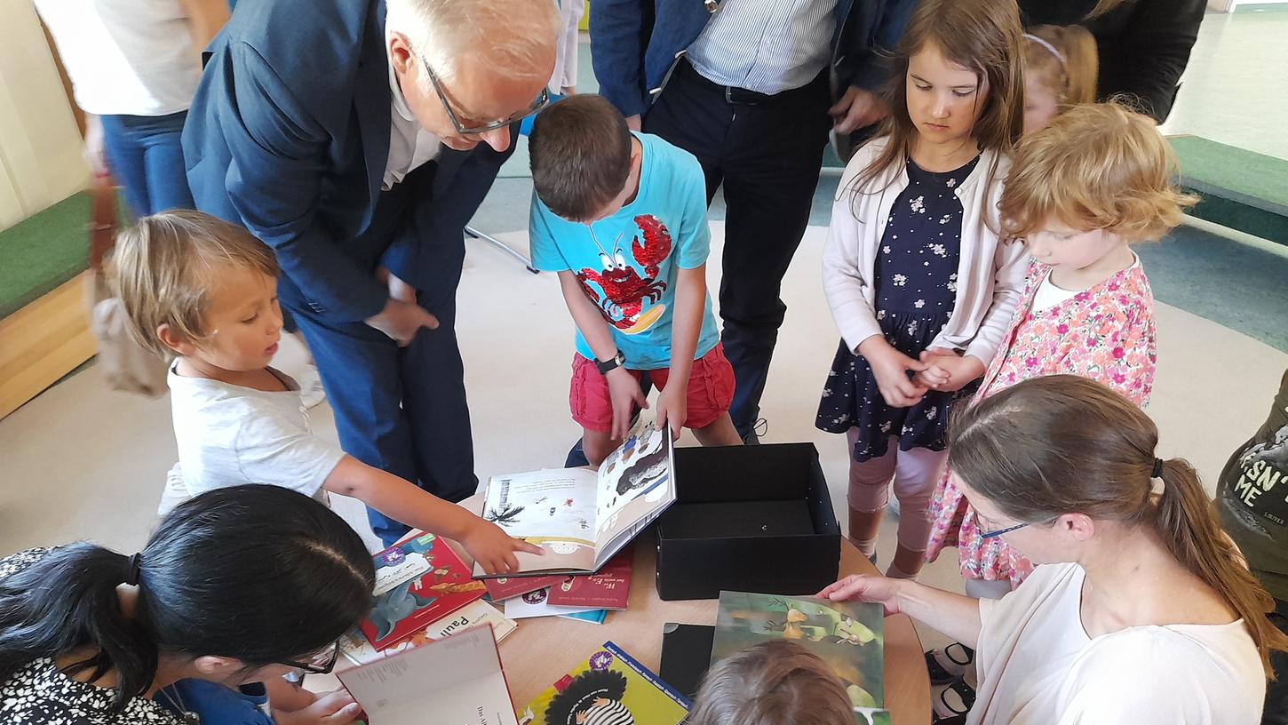 Die Kinder des Anne-Frank-Kindergartens schauen sich mit ihren Eltern und Sozialreferent Knut Engelbrecht die mehrsprachigen Bilderbücher an. 