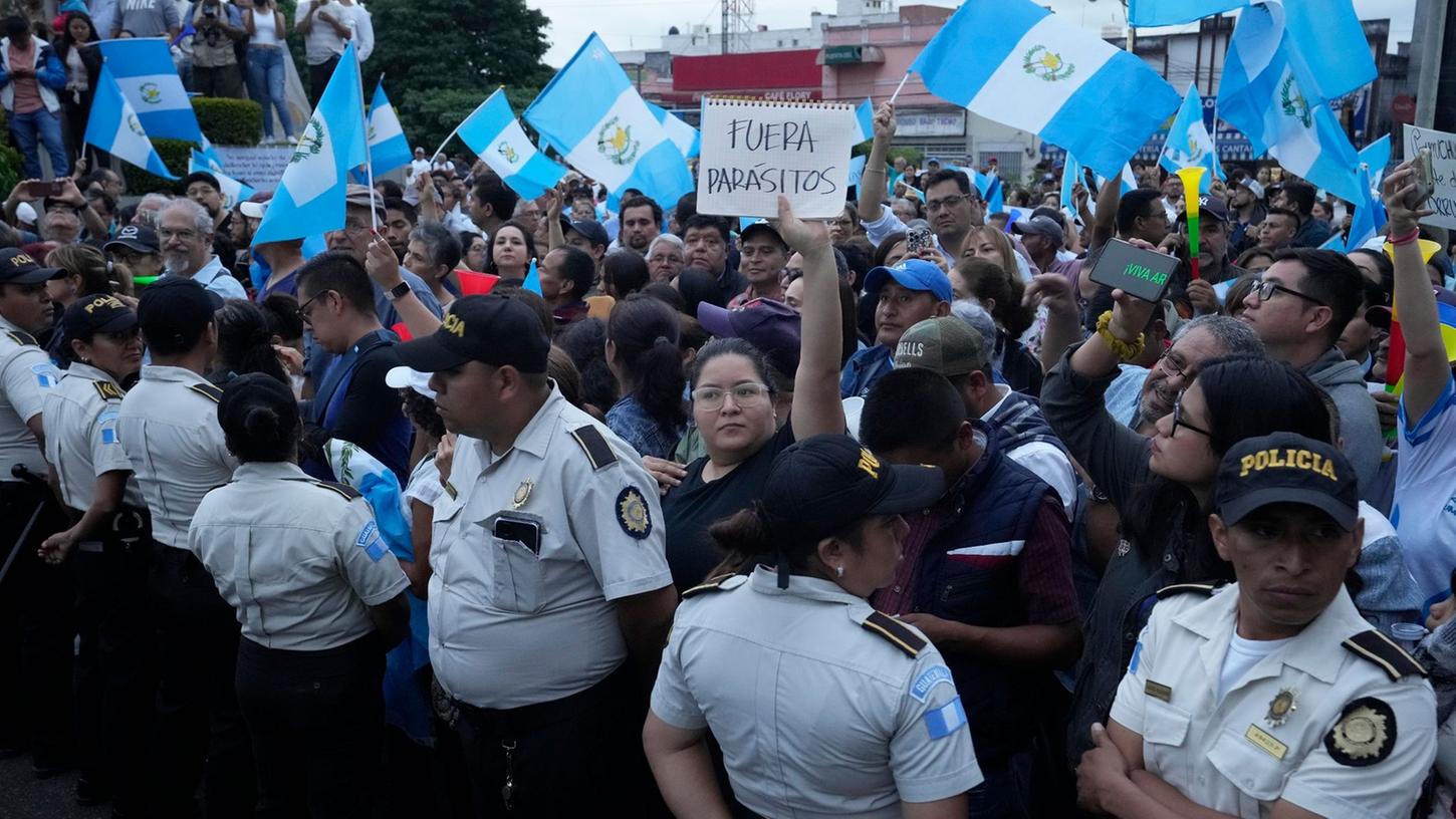 Während einer Demonstration in der Hauptstadt hält eine Frau ein Schild mit der Aufschrift "Parasiten raus" in die Höhe. Tausende Menschen protestieren in Guatemala gegen die Generalstaatsanwaltschaft. Während einer Demonstration in der Hauptstadt hält eine Frau ein Schild mit der Aufschrift "Parasiten raus" in die Höhe. Tausende Menschen protestieren in Guatemala gegen die Generalstaatsanwaltschaft.