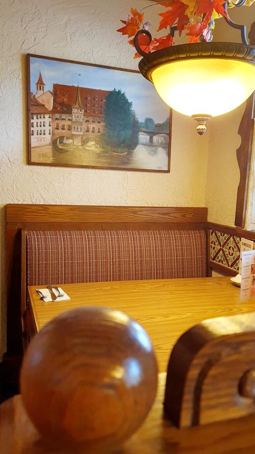 Die gute Stube im Frühstücksraum des Bavarian Inn - eine Tischecke wie in einem fränkischen Gasthaus, mit einem Bild des Nürnberger Heilig-Geist-Spitals.
