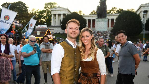 Die Tochter des Bayerischen Ministerpräsidenten Selina Söder und ihr Partner Raphael Netz stehen auf dem Oktoberfest vor der Bavaria.