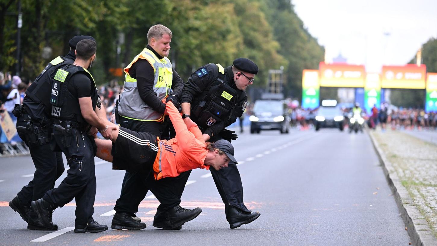 Ein Aktivist wird vor dem Start des Marathon von Polizisten weggetragen.