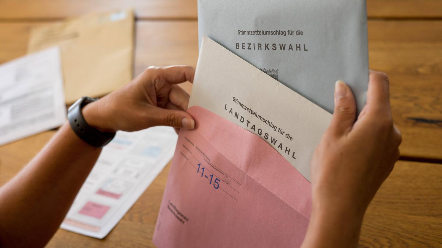 Eine Wählerin bereitet ihre Stimmzettel und Briefwahlunterlagen für die Landtagswahl am 8. Oktober in Bayern vor.