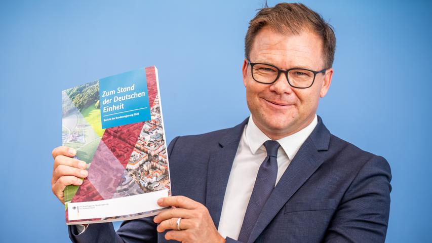 Licht und Schatten: Carsten Schneider (SPD), Staatsminister und Ostbeauftragter der Bundesregierung, zeigt den Bericht zum Stand der Deutschen Einheit. Am 3. Oktober jährt sich die deutsche Wiedervereinigung zum 33. Mal. Licht und Schatten: Carsten Schneider (SPD), Staatsminister und Ostbeauftragter der Bundesregierung, zeigt den Bericht zum Stand der Deutschen Einheit. Am 3. Oktober jährt sich die deutsche Wiedervereinigung zum 33. Mal.