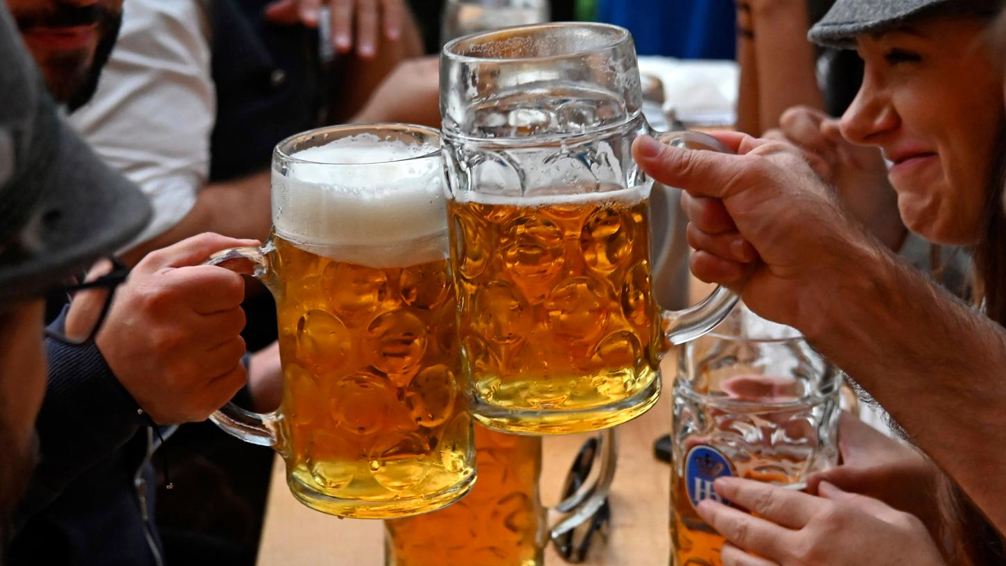 Feiernde mit Bierkrügen beim 188. Oktoberfest 2023 auf der Theresienwiese.