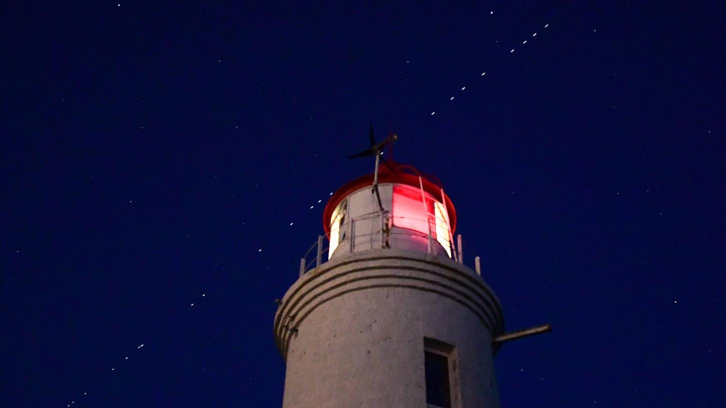 Immer wieder sorgen Lichterketten am Nachthimmel, hier über einem Leuchtturm im russischen Wladiwostok, für Verwunderung (Symbolbild). Immer wieder sorgen Lichterketten am Nachthimmel, hier über einem Leuchtturm im russischen Wladiwostok, für Verwunderung (Symbolbild).