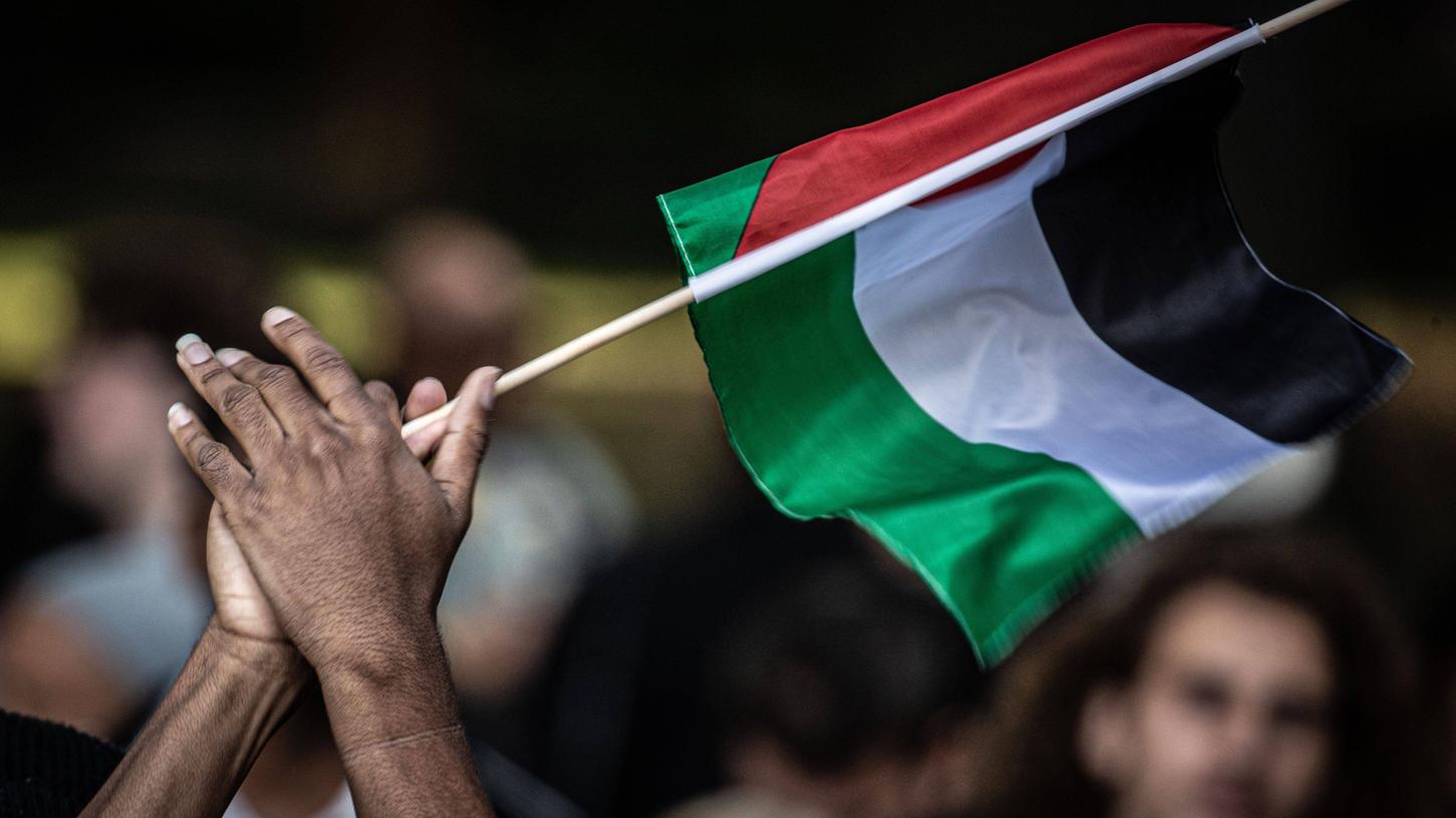 Ein Teilnehmer einer Pro-Palästina Demonstration schwenkt eine Palästina-Flagge. (Symbolbild)