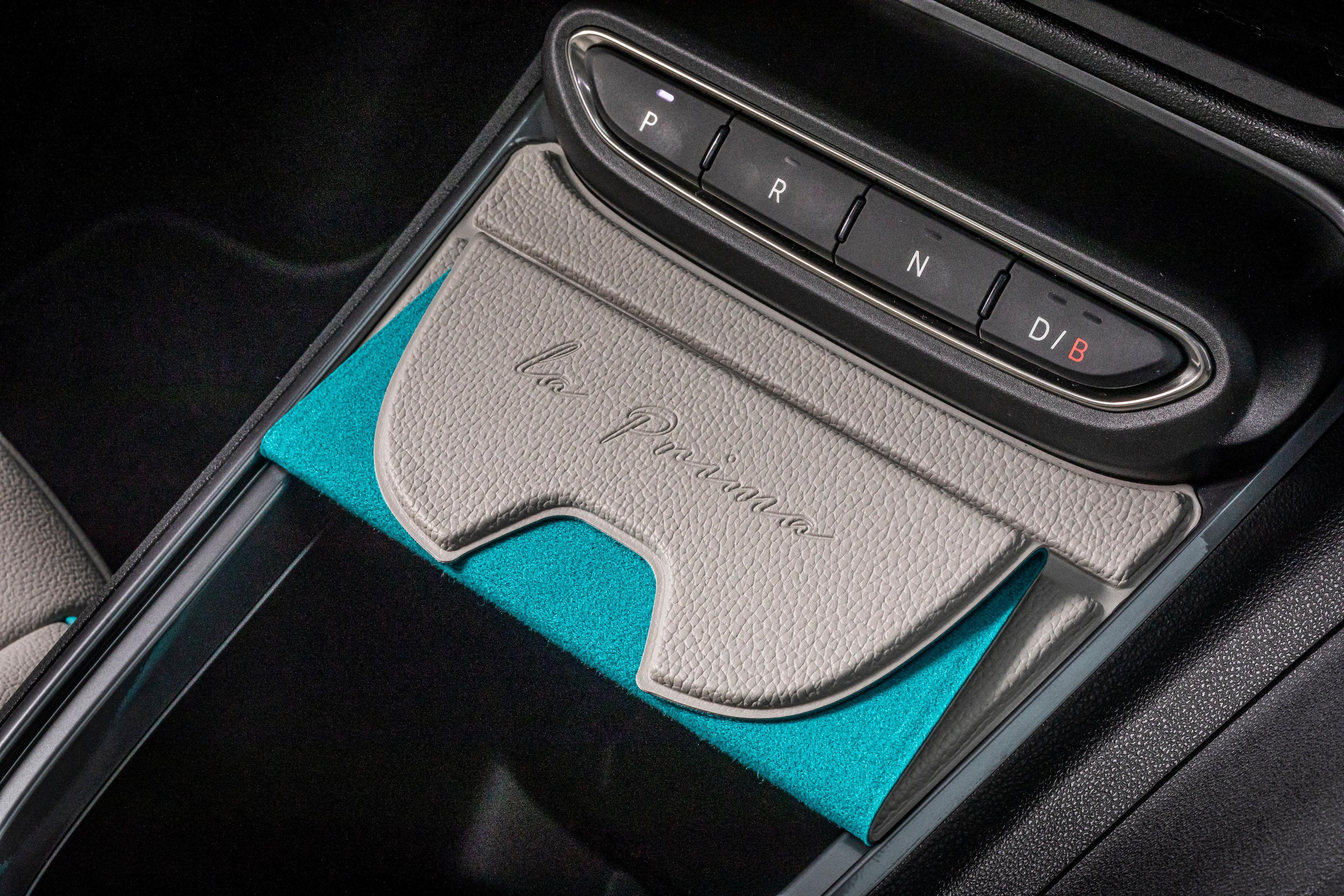 Die Fahrstufen werden über Taster angesteuert. Das kennt man vom Fiat 500e und vom Jeep Avenger, von dem der 600e auch diese Magnet-Abdeckung fürs Staufach übernimmt.