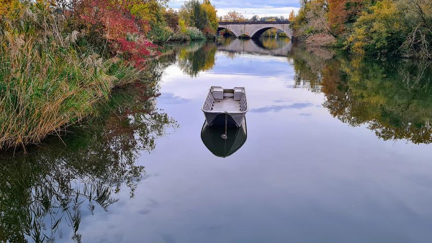 Ein leeres Boot spiegelt sich im Main in Kitzingen. Mehr Leserfotos finden Sie hier