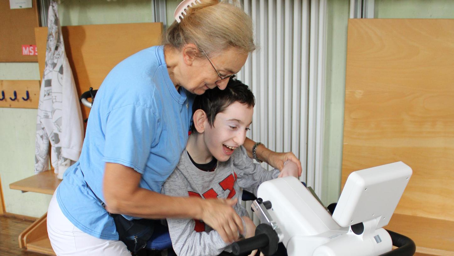 Das neue Trainingsgerät im Einsatz: Im Blindeninstitut Rückersdorf hilft Bettina Wittmann dem 15-jährigen Gagik, Arme und Beine 