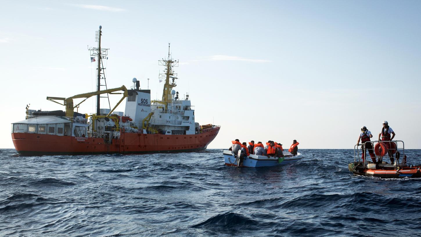 2018 vor der libyschen Küste: Kleine Boote mit Flüchtlingen schwimmen vor dem Seenotrettungsschiff Aquarius 2 der Hilfsorganisation SOS Mediterranée. Weil Seenotrettungsschiffe in europäischen Häfen nicht anlegen durften, wurde damals die Seebrücke gegründet.