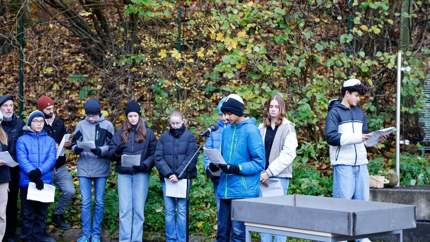 Schülerinnen und Schüler des Albert-Schweitzer-Gymnasiums Erlangen entzündeten Kerzen zum Gedenken an die Erlanger Opfer der Judenverfolgung, verlasen deren Namen und Alter und legten Steine zum Gedenken aus.