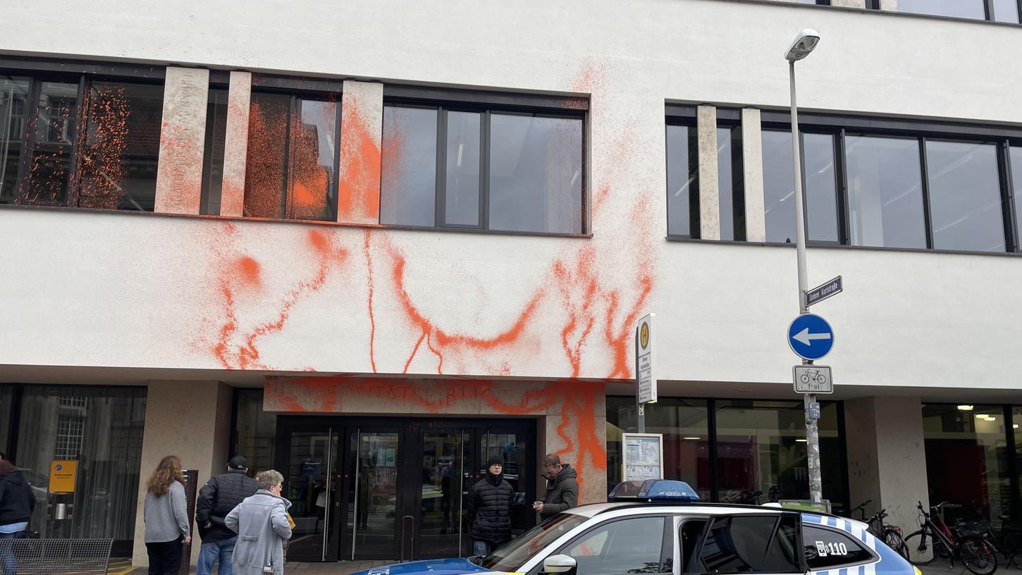 Mit orangener Warnfarbe haben Klimaaktivisten die Unibibliothek in Erlangen bespüht. Die Polizei ist vor Ort. 