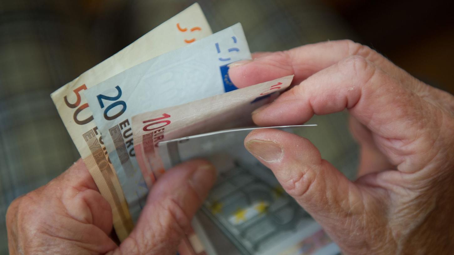 Eine ältere Frau zählt Geld. Eine ältere Frau zählt Geld.