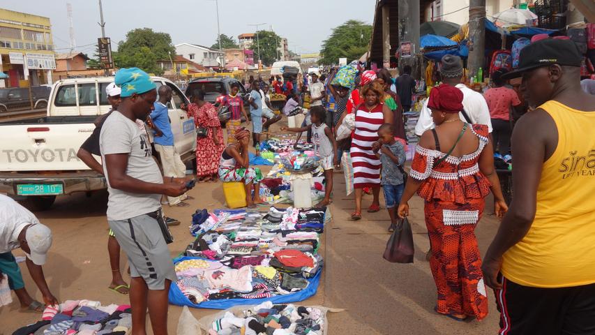 Eine Marktszene aus der Hauptstadt Bissau. Der dortige Bandim-Markt ist die Einkaufsstraße der Stadt. Direkt auf dem Bürgersteig wird hier nahezu alles verkauft - vielfach Second-Hand-Ware aus Europa.