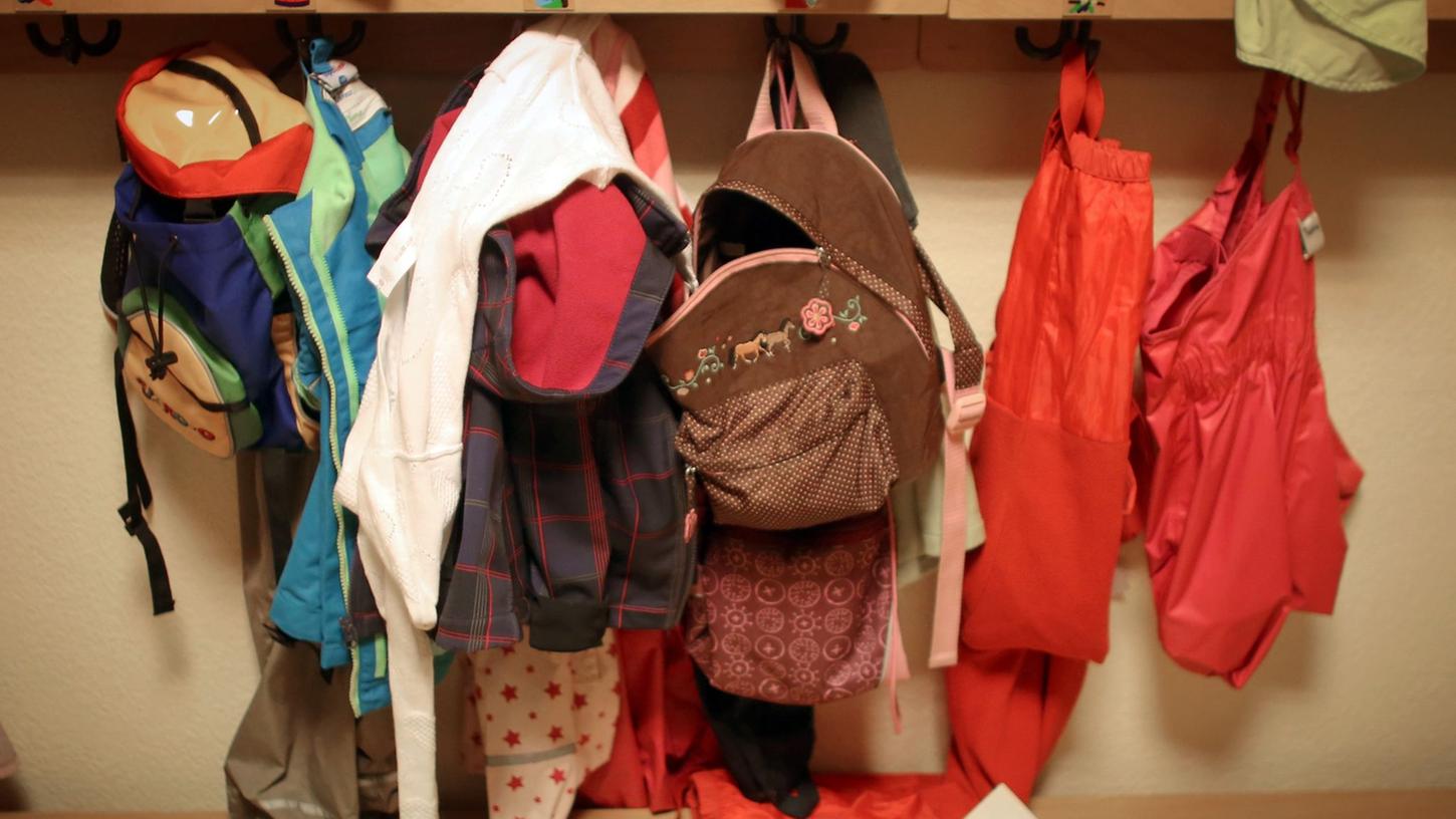 Jacken und Rucksäcke von Kindern in der Garderobe einer Betriebskita.