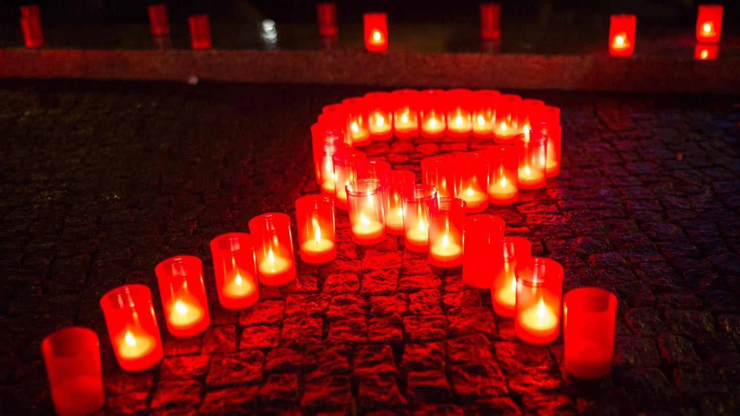 Die rote Schleife ist ein Symbol für den Kampf gegen Aids. Hier wurde sie bei einem Aktionstag in Berlin mit Kerzen geformt. Die rote Schleife ist ein Symbol für den Kampf gegen Aids. Hier wurde sie bei einem Aktionstag in Berlin mit Kerzen geformt.