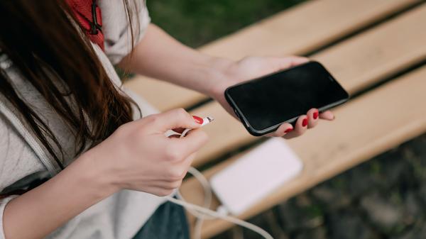 Close up of connecting usb c cable to the port of the modern phone. Charging modern phone, inserting cable to the port