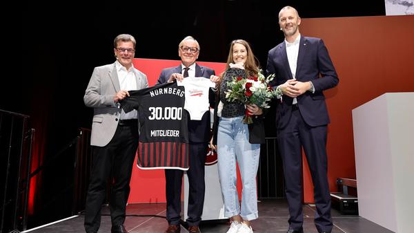Das 30.000. Mitglied des FCN ist eine Frau - und kam nicht allein nun auf das Podium. Jana Strauch hat ihr frischgeborenes Kind im Tragetuch dabei.
