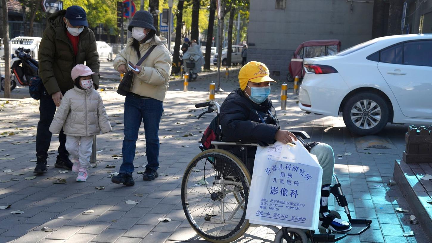 Ein Junge in einem Rollstuhl hält in Peking eine Tasche aus der radiologischen Abteilung eines Kinderkrankenhauses. In den vergangenen Tagen hatten Berichte über die starke Häufung von Atemwegserkrankungen bei Kindern Sorgen aufkommen lassen.