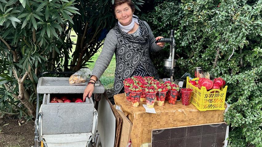 Diese Frau hofft mit einem Kinderwagen voller Granatäpfel auf ein gutes Geschäft an der Seilbahn-Station.