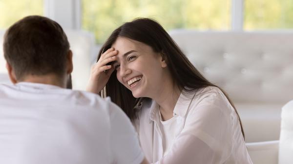 Beautiful young woman laughs sit in cafe with boyfriend