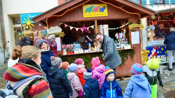 Der Stand der Schwabacher Kinderstube erhielt bald nach dem Auftakt einen Kontrollbesuch. Etwa zehn Kindergartenkinder samt Erzieherinnen und einigen Eltern machten vor dem Bummel über den Weihnachtsmarkt dort halt und präsentierten sich mit selbstgebastelten Kerzen. Zugleich stießen sie auf den Oberbürgermeister: Peter Reiß wollte sich auf dem Weihnachtsmarkt zu Füßen seines Büros Inspirationen für seine Weihnachtsgeschenke holen.