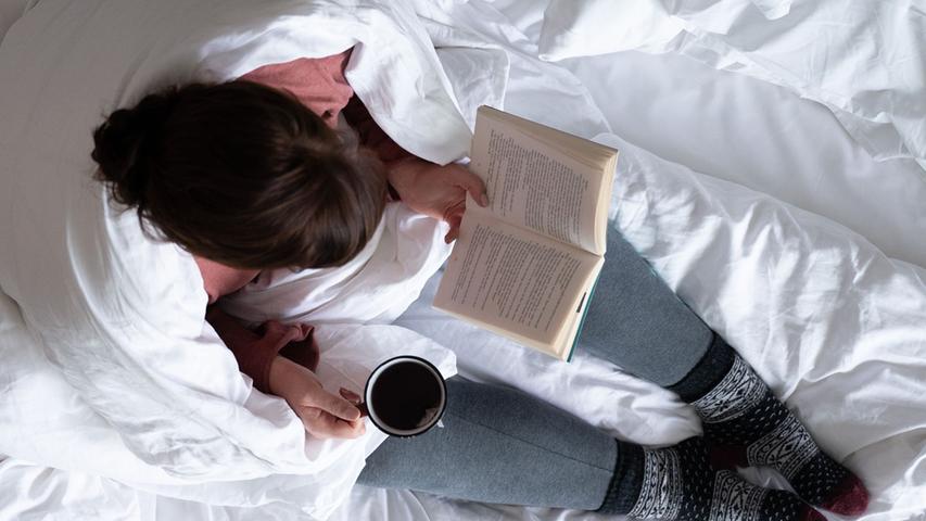 Eine Tasse Tee und ein gutes Buch können beim Einschlafen helfen.