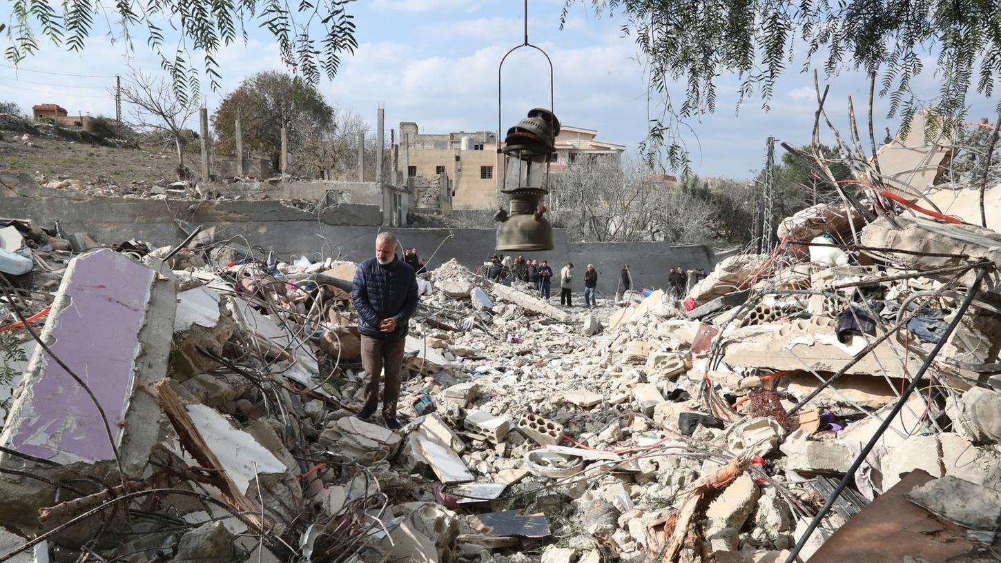 Ein libanesischer Mann in Bint Dschubail auf den Trümmern eines Hauses, welches durch einen israelischen Luftangriff zerstört worden ist.