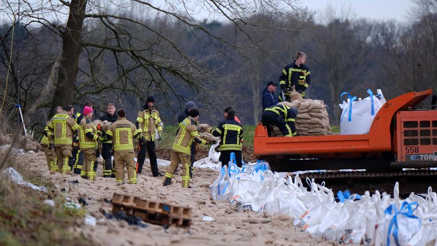 Niedersachsen, Sandkrug: Feuerwehrleute sichern einen Deich bei Sandkrug. 