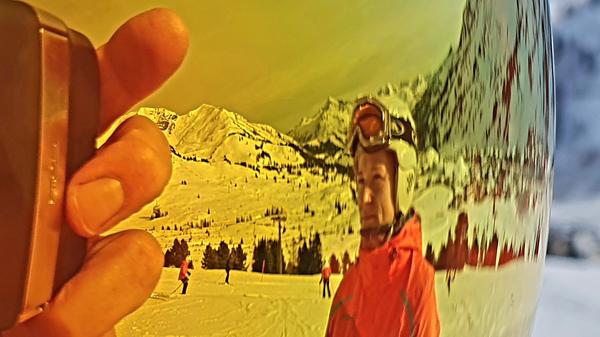 Die Bergwelt spiegelt sich in der Skibrille.