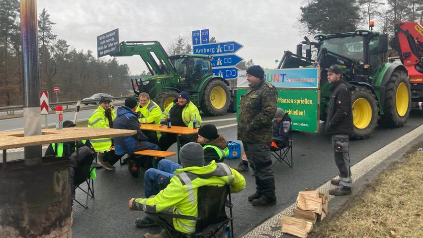 Gemütlich mit Bierbank aufgestellt blockieren Landwirte die Autobahnauffahrt Nürnberg Nord auf die A3.