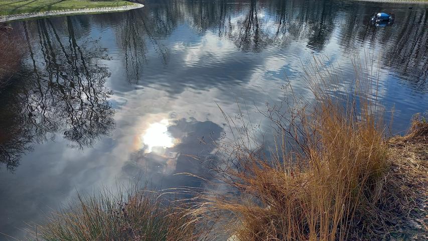 Die durch die Wolken brechende Sonne spiegelt sich im Wasser im Nürnberger Stadtpark. Mehr Leserfotos finden Sie hier