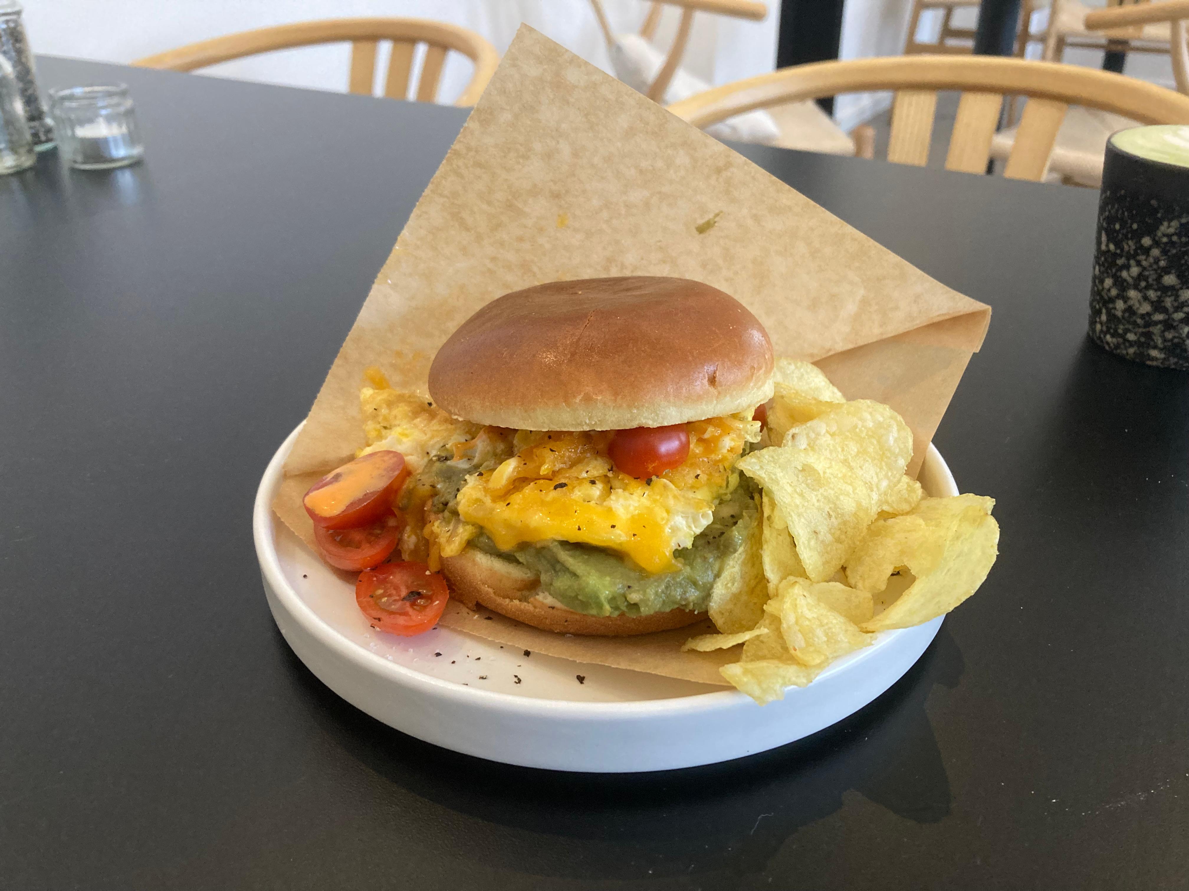 Eines der Highlights auf der Karte des Sundays: der Breakfast Burger mit cremigem Rührei, Avocado, Käse, Tomaten und veganer Sriracha-Mayo im Brioche Bun.