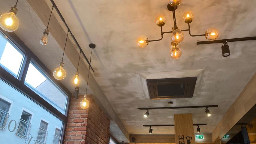 Klinkerwände und unverputzte Decken treffen im Café Date House auf Industrial-Kronleuchter und mit Holz verkleidete Wände.