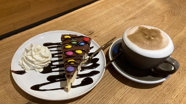 Oder doch lieber ein Foto des geliebten Vierbeiners? Mit dem Milchschaum-Druck sind der Vorstellung keine Grenzen gesetzt. Links ist ein Schoko-Käsekuchen mit Smarties zu sehen.