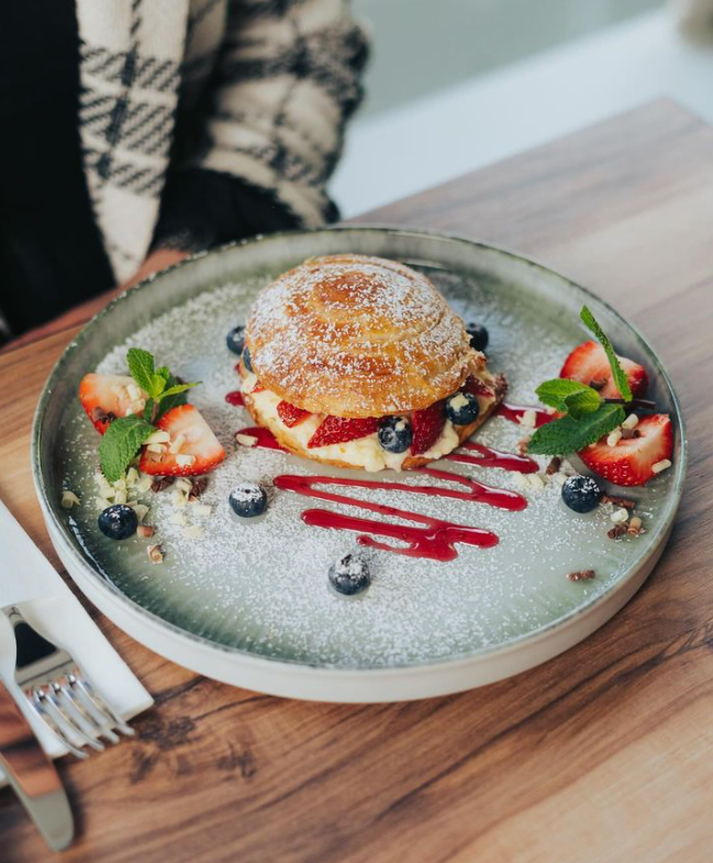 Croissant-Törtchen mit cremigem Vanillepudding, frischen Erdbeeren und Blaubeeren - "Erbeerliebe" heißt das Gericht auf der Karte.