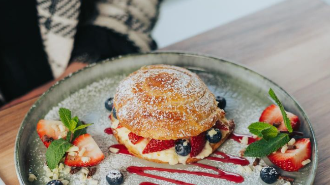 Croissant-Törtchen mit cremigem Vanillepudding, frischen Erdbeeren und Blaubeeren - "Erbeerliebe" heißt das Gericht auf der Karte.