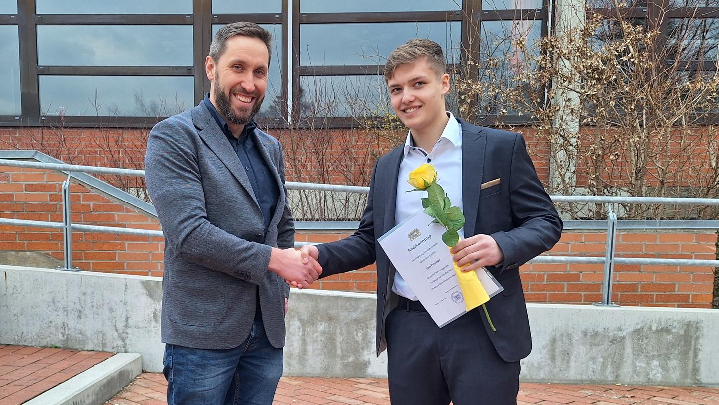 Ausbildungsleiter Stefan Bachmeier gratuliert Elias Prosiegel zum Staatspreis. 