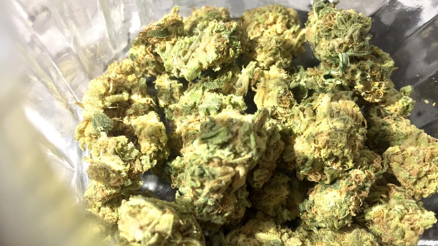 Cannabisblüten liegen in einem Glas.
