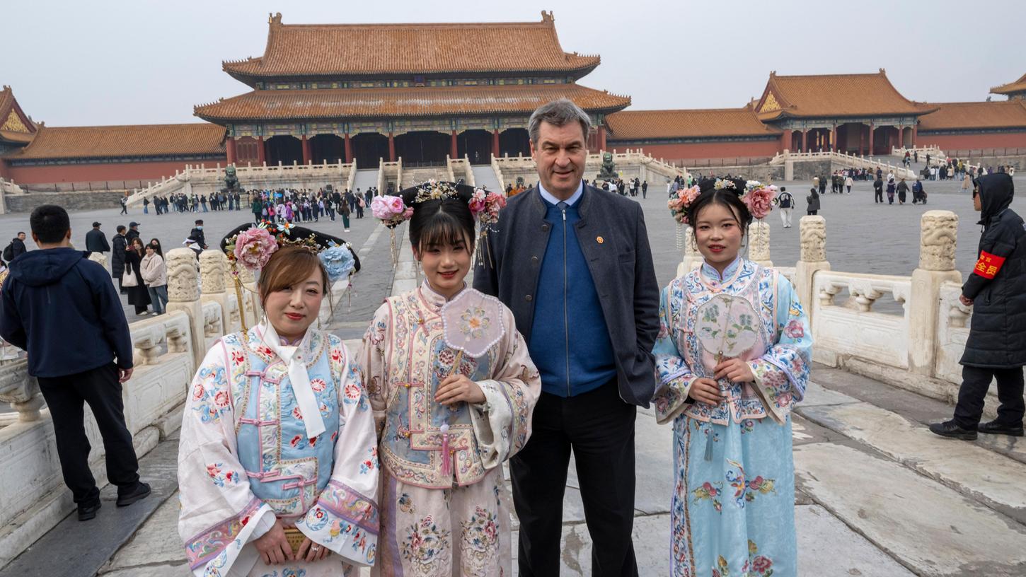 Der bayerische Ministerpräsident besuchte auch die historische Verbotene Stadt in der chinesischen Hauptstadt - und stellte sich für ein Foto neben Frauen in traditionellen Kostümen. 