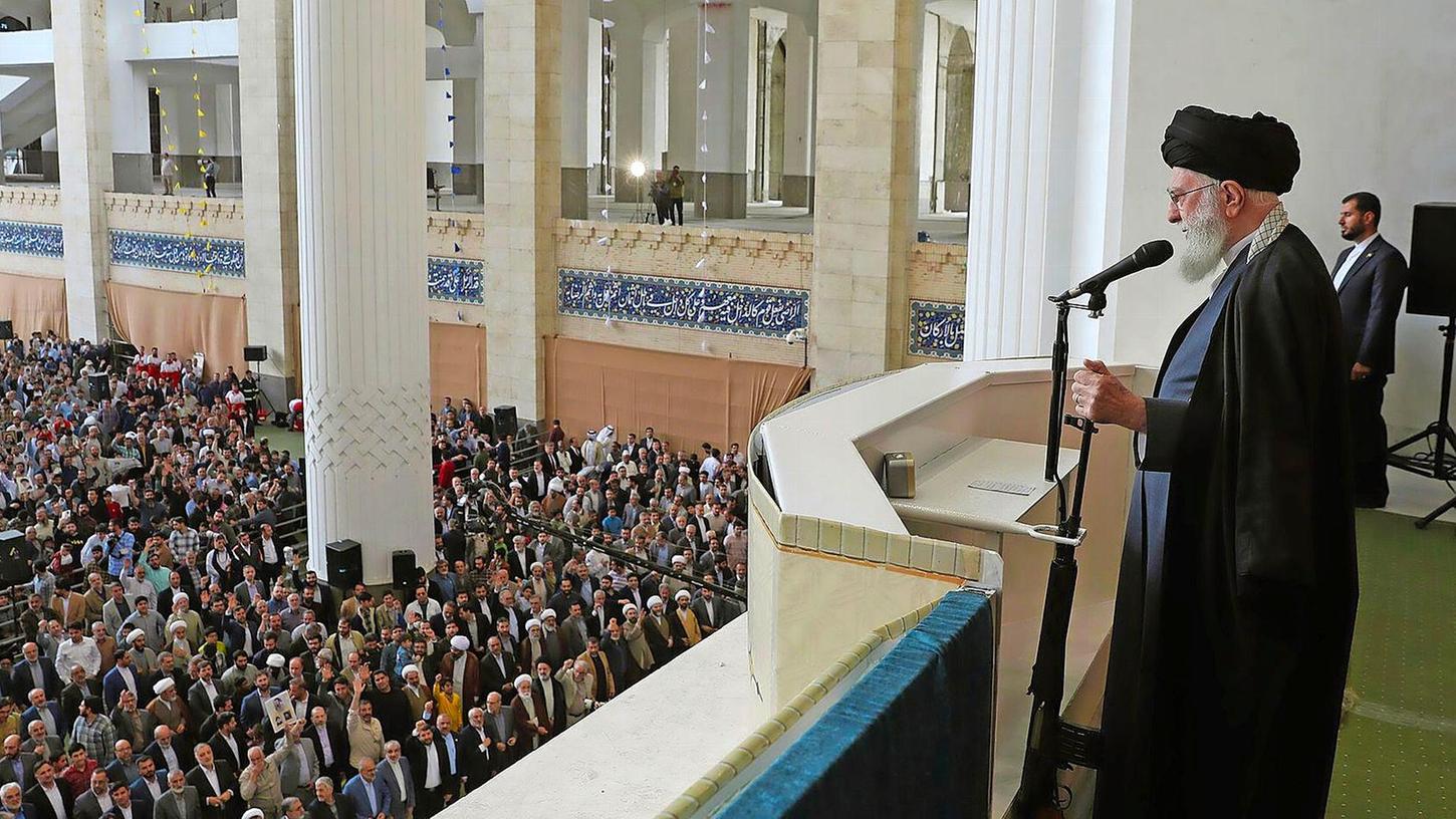 Ajatollah Ali Chamenei hält bei seiner Rede den Lauf eines Gewehrs in der Hand.