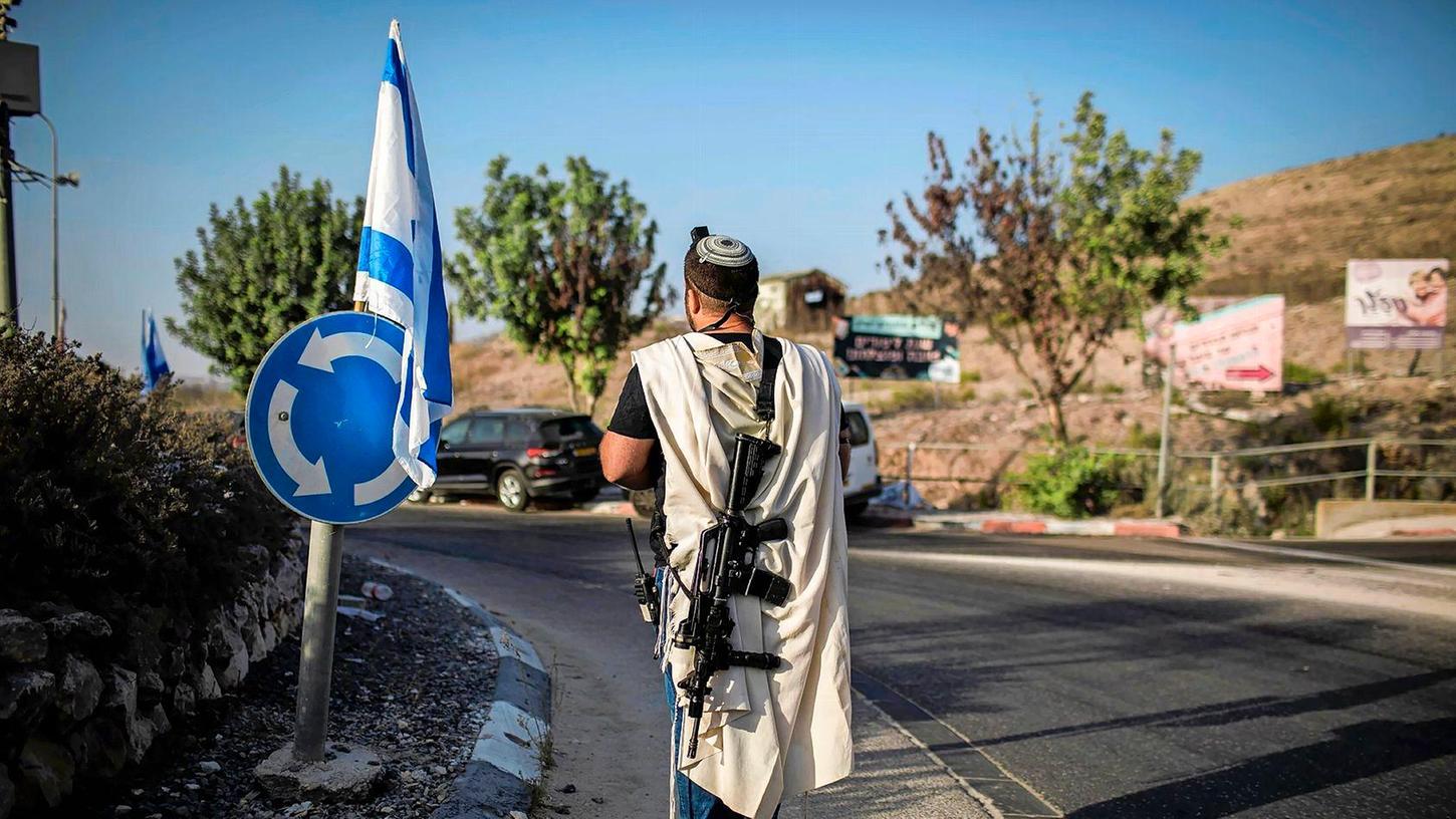 Ein rechtsgerichteter israelischer Siedler trägt eine Waffe nahe der palästinensischen Stadt Nablus im Westjordanland (Archivfoto). Die EU verhängt erstmals Sanktionen wegen der Gewalt radikaler israelischer Siedler.