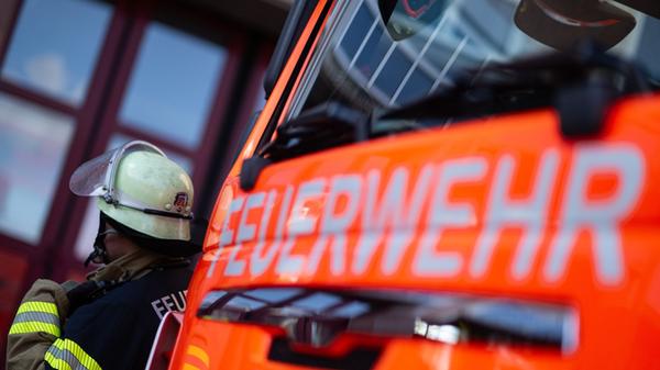 Feuerwehrmann steht neben einem Feuerwehrauto