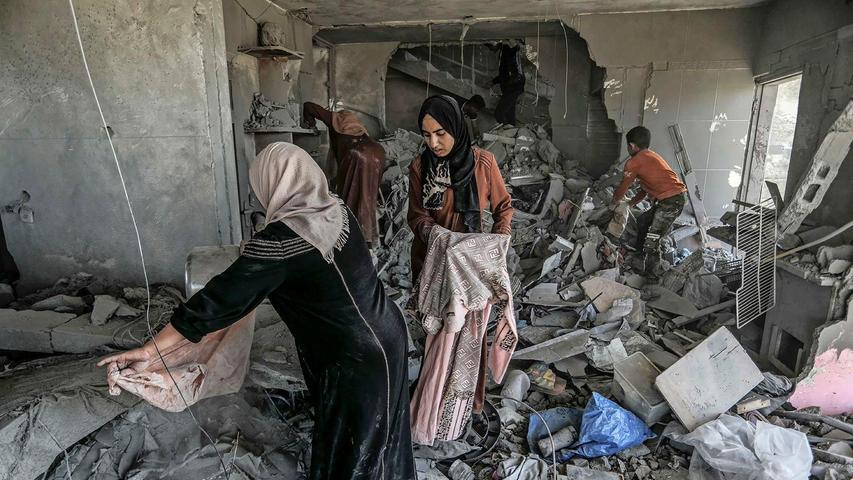 Palästinenserinnen suchen in einem zerstörten Haus in Rafah nach Habseligkeiten.