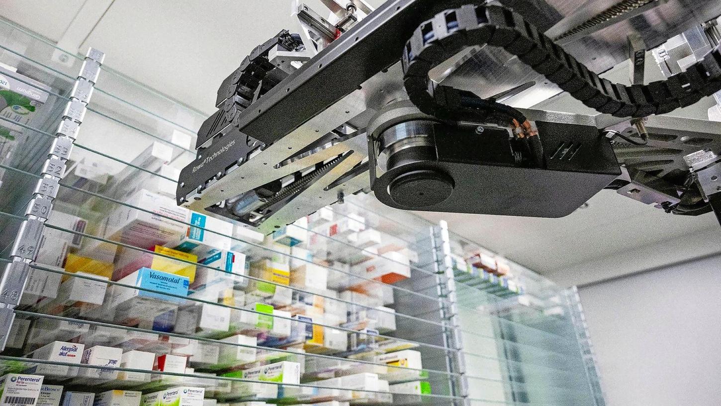 Ein Automat sucht in einer Apotheke ein Medikament für einen Kunden aus dem Warenlager heraus.