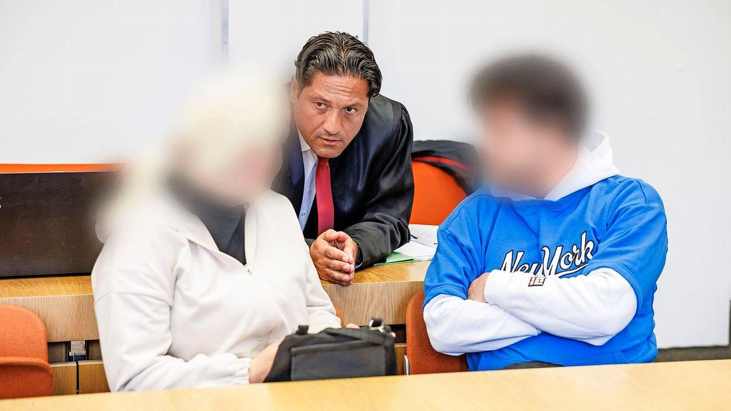 Rechtsanwalt Ömer Sahinci redet mit seinen Mandanten, einem wegen Erpressung angeklagten angeblichen Hellseher und dessen ebenfalls wegen Erpressung mitangeklagten Ehefrau vor Prozessbeginn in einem Gerichtssaal im Landgericht München.