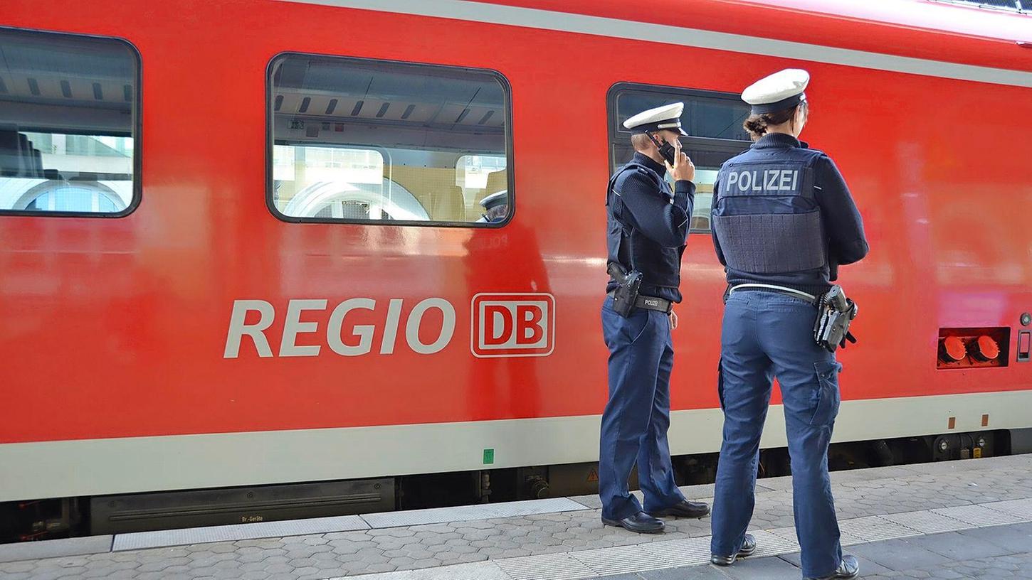 Polizisten vor einem Regionalzug (Symbolfoto).
