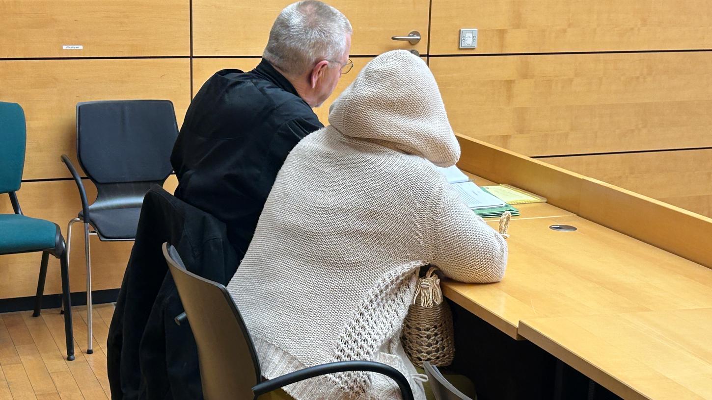 Eine der beiden Angeklagten sitzt mit ihrem Verteidiger im Gerichtssaal. Die Frau und ein Mann sollen im Januar 2021 geholfen haben, Plakate über den Gleisen einer Bahnstrecke aufzustellen.