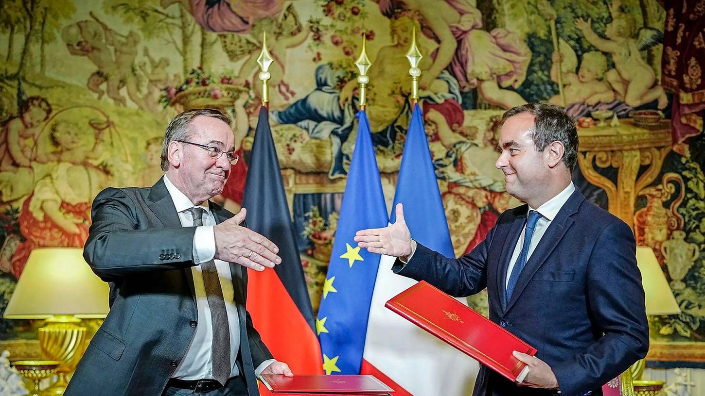 Boris Pistorius (l) und Sébastien Lecornu geben sich nach der Unterzeichnung der Absichtserklärung beider Länder für das Kampfpanzersystem der Zukunft die Hand.