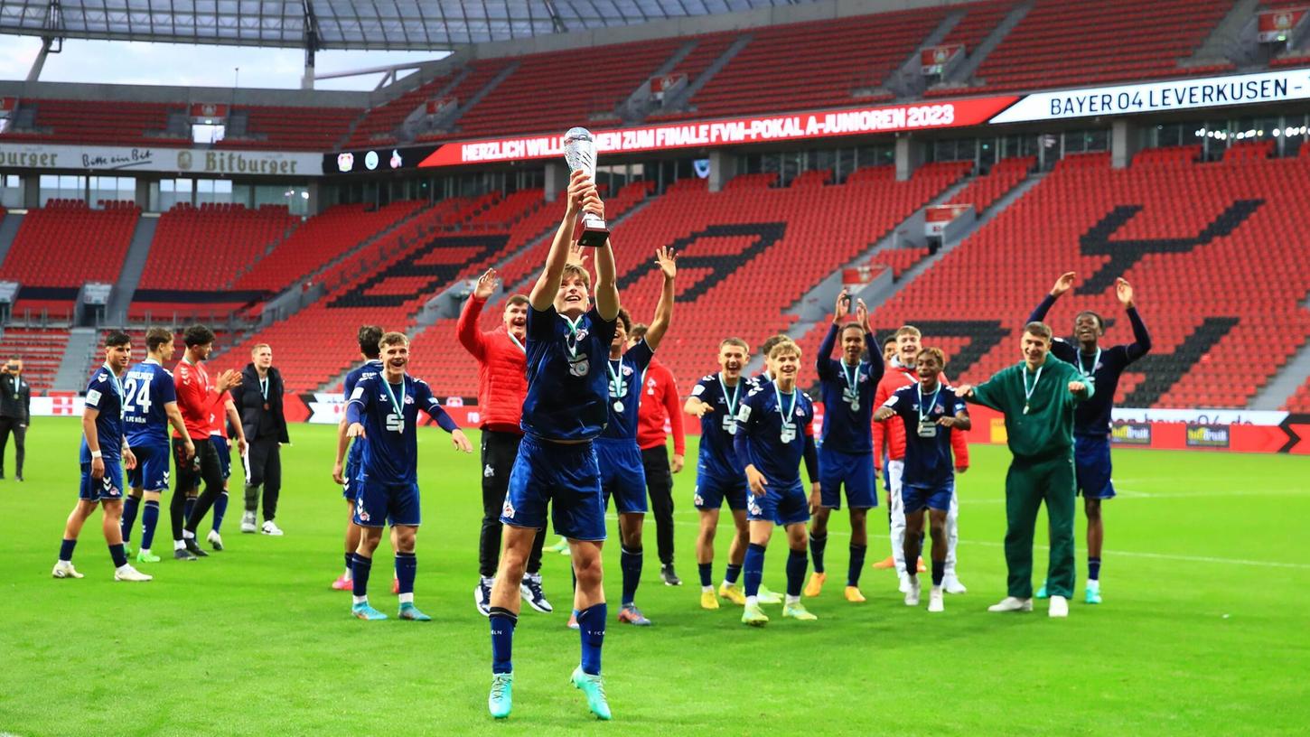 Spieler der Kölner A-Jugend feiern den Gewinn im Mittelrhein-Pokal. Fürths Neuzugang Matti Wagner streckt den Pokal in die Höhe.